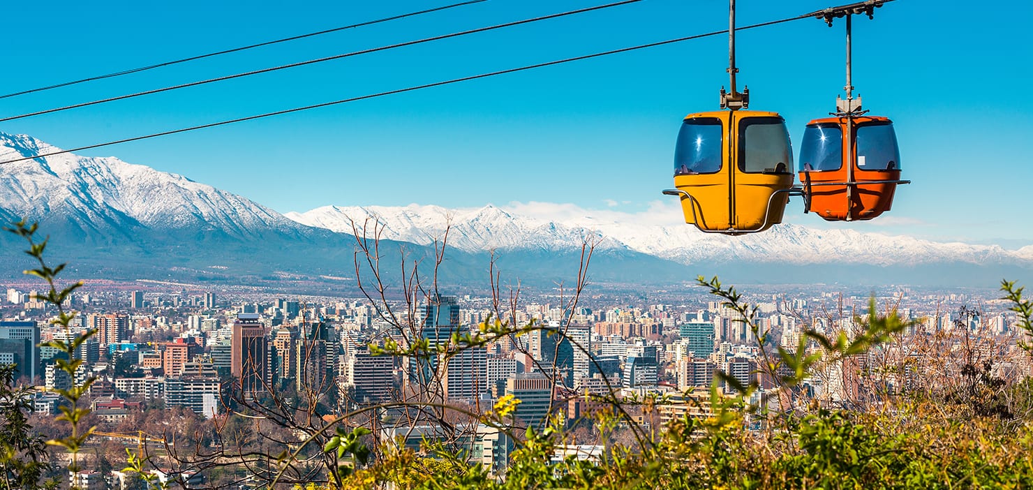 Panorama view of Santiago and mountain range with cable cars in the foreground.